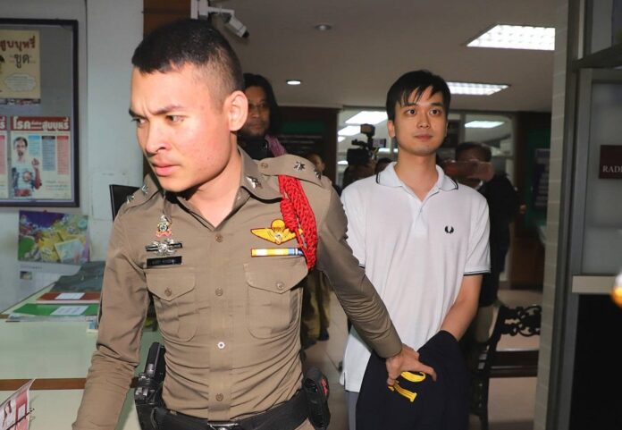Police escort Karn Pongpraphapan to an interrogation at a police station in Bangkok on Oct. 8, 2019.