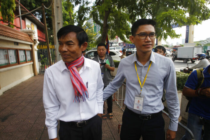 Journalists Uon Chhin, left, and Yeang Sothearin, right, arrive at the municipal court, in Phnom Penh, Cambodia, Thursday, Oct. 3, 2019. A Cambodian court has ordered a new investigation and postponed a verdict in the espionage trial of two journalists who had worked for a U.S. Government-backed radio station. Photo: Heng Sinith / AP