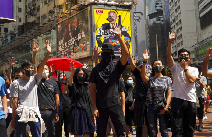 Protesters wear masks and hold up their hands to represent their five demands in Hong Kong Friday, Oct. 4, 2019. Hong Kong pro-democracy protesters marched in the city center Friday ahead of plans by the city’s embattled leader to deploy emergency powers to ban people from wearing masks in a bid to quash four months of anti-government demonstrations. Photo: Vincent Yu / AP