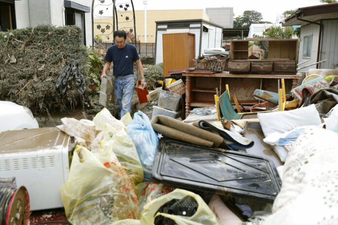 A man carries household goods out of a flooded house in Motomiya, Fukushima prefecture, Japan Tuesday, Oct. 15, 2019. Photo: Kyodo News via AP