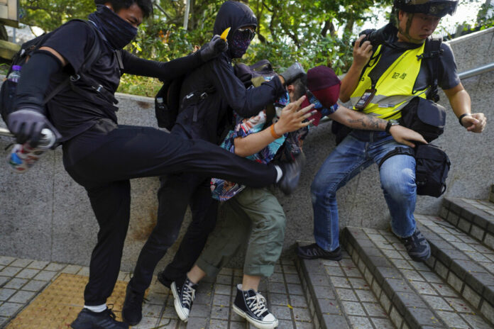 Protesters attack a man who was trying to stop them for vandalizing near the Tsim She Tsui police station during a rally in Hong Kong, Sunday, Oct. 20, 2019. Hong Kong protesters again flooded streets on Sunday, ignoring a police ban on the rally and demanding the government meet their demands for accountability and political rights. Photo: Vincent Yu / AP