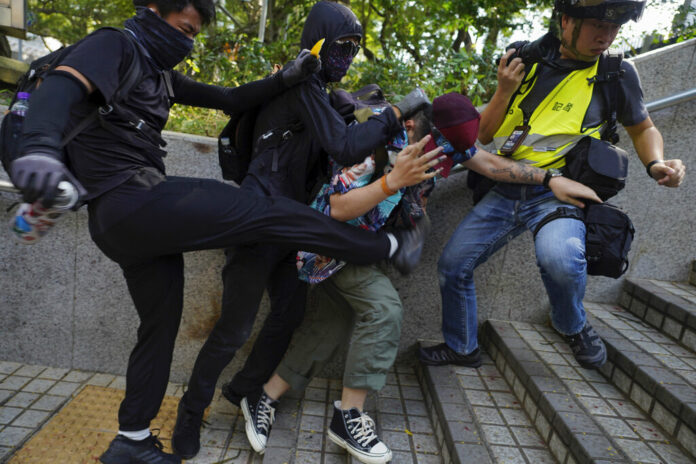 Protesters attack a man who was trying to stop them for vandalizing near the Tsim She Tsui police station during a rally in Hong Kong, Sunday, Oct. 20, 2019. Hong Kong protesters again flooded streets on Sunday, ignoring a police ban on the rally and demanding the government meet their demands for accountability and political rights. Photo: Vincent Yu / AP Protesters attack a man who was trying to stop them for vandalizing near the Tsim She Tsui police station during a rally in Hong Kong, Sunday, Oct. 20, 2019. Hong Kong protesters again flooded streets on Sunday, ignoring a police ban on the rally and demanding the government meet their demands for accountability and political rights. Photo: Vincent Yu / AP