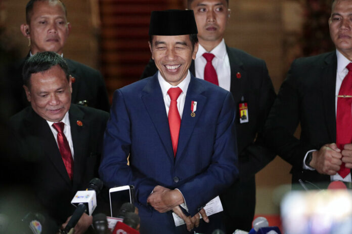 Indonesian President Joko Widodo, center, smiles as he speaks to the media upon arrival after his inauguration for his second term, at Merdeka Palace in Jakarta, Indonesia, Sunday, Oct. 20, 2019. Widodo, who rose from poverty and pledged to champion democracy, fight entrenched corruption and modernize the world's most populous Muslim-majority nation, was sworn in Sunday for his second and final five-year term with a pledge to take bolder actions. Photo: Dita Alangkara / AP