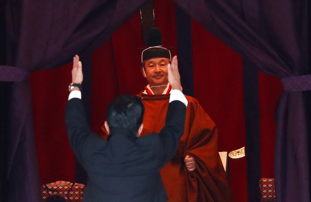 Japan's Prime Minister Shinzo Abe raises his hands as he shouts "banzai" or cheers in front of Emperor Naruhito during a ceremony to proclaim Emperor Naruhito's enthronement to the world, called Sokuirei-Seiden-no-gi, at the Imperial Palace in Tokyo, Japan, Tuesday, Oct. 22, 2019. Photo: Issei Kato / Pool Photo via AP