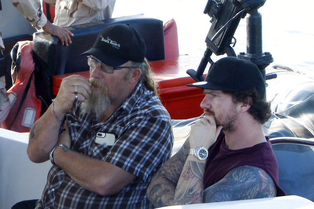 Harry Bambridge, right, brother of missing British backpacker Amelia Bambridge, sits on a speedboat before leaving to search for her with Cambodian provincial authority at Koh Rong island off southwestern Cambodia, Wednesday, Oct. 30, 2019. Photo: Heng Sinith / AP