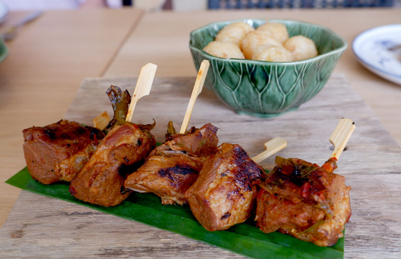 Grilled Pork Collar with Chamuang Leaves and Seared Rice Cake (270 baht).