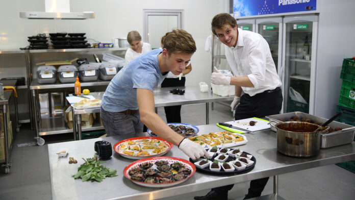 Volunteers for Scholars of Sustenance cooking food from leftover ingredients at FREC Bangkok on June 17.