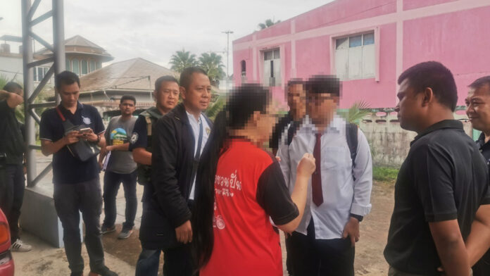 Thiranat Mahatthanobol, standing to the right of his mother in red shirt, during a police raid at his home in Pattani on Oct. 28, 2019.