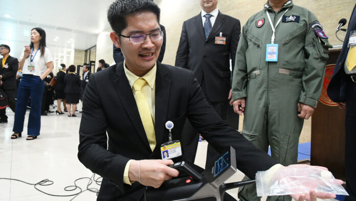 Thai Civilized Party leader Mongkolkit Suksintaranont uses a trace detector to identify a sample of TNT during a press conference on Oct. 30, 2019.