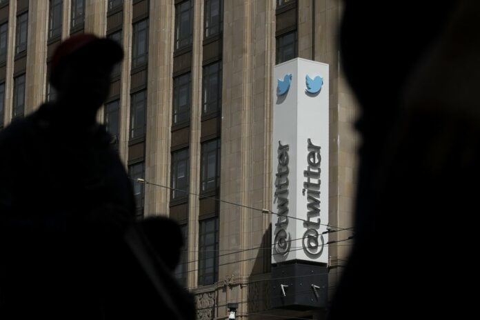 This July 9, 2019, file photo shows pedestrians walking across the street from the Twitter office building in San Francisco. The Saudi government recruited two Twitter employees to get personal account information of their critics, prosecutors said Wednesday, Nov. 6, 2019. (AP Photo/Jeff Chiu, File)