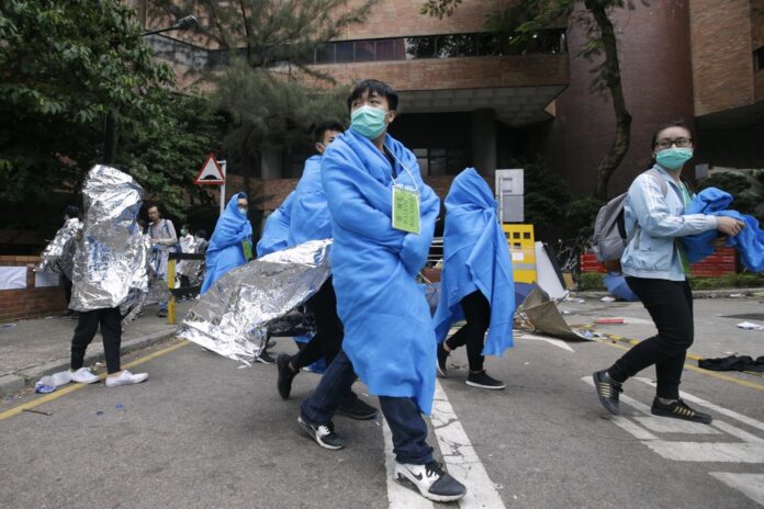 Injured protesters wrapped in blankets, walk through the campus of the Hong Kong Polytechnic University in Hong Kong, Tuesday, Nov. 19, 2019. (AP Photo/Achmad Ibrahim)