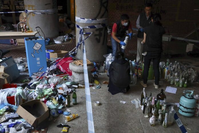 Police collect molotov cocktails and flammable materials used by protesters as evidence in a cordoned off area on the Polytechnic University campus in Hong Kong, Thursday, Nov. 28, 2019. (AP Photo/Ng Han Guan)