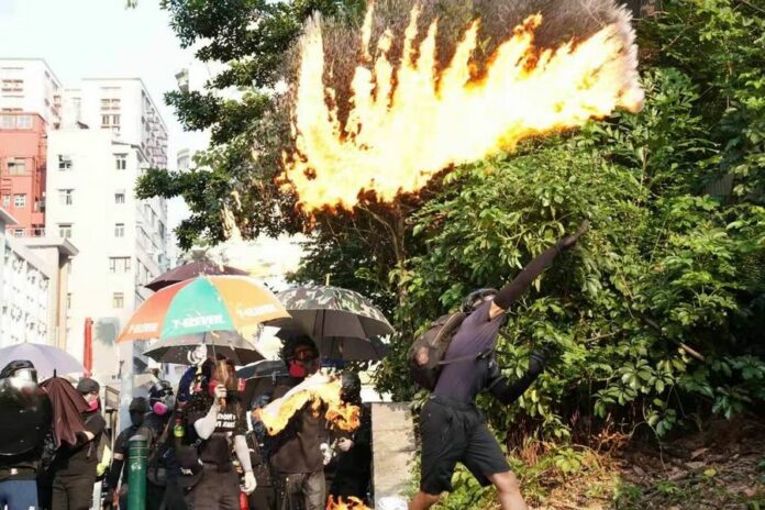 Rioters throw petrol bombs at the Tsim Sha Tsui police station in Hong Kong, south China, Oct. 20, 2019. (Xinhua)