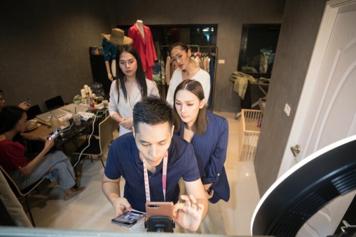 Nunthapong Boonnao (Front) and Manassawee Suangkaew (1st, R) go on live-streaming to promote their online clothing shop registered in Lazada, a major online shopping company in Southeast Asia, at Bangkok, Thailand, Oct. 21, 2019. Photo: Zhang Keren / Xinhua