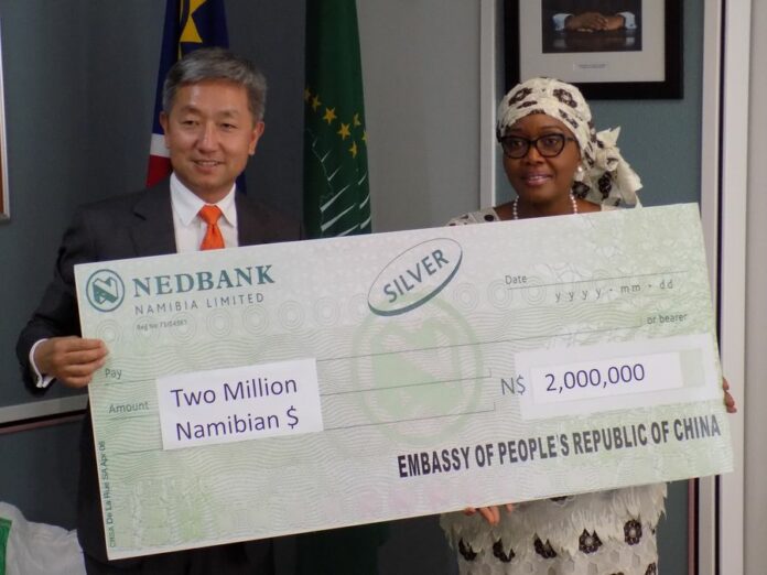 Chinese Ambassador to Namibia, Zhang Yiming (L) hands over drought relief donation raised by the Chinese business community in Namibia to Namibia's Prime Minister Saara Kuugongelwa-Amadhila (R) in Windhoek, Namibia, Nov. 25, 2019. (Xinhua/Musa C Kaseke)