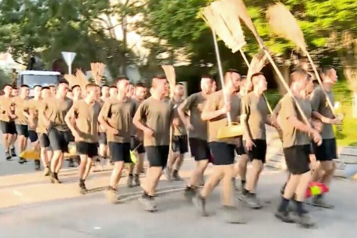In this image made from video, People’s Liberation Army soldiers, with brooms, arrive to clean up the protest area at Hong Kong Baptist University in Hong Kong, Saturday, Nov. 16, 2019. (Television Broadcasts Limited Hong Kong via AP)