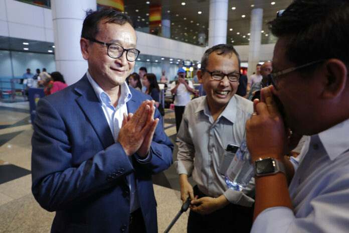 Cambodia's exiled opposition leader Sam Rainsy, left, greets supporters as he arrived at Kuala Lumpur International's Airport in Sepang, Malaysia Saturday, Nov. 9, 2019. Sam Rainsy landed in Kuala Lumpur in a bid to return to his homeland after Thailand had earlier blocked him from entering. Photo: Vincent Thian / AP