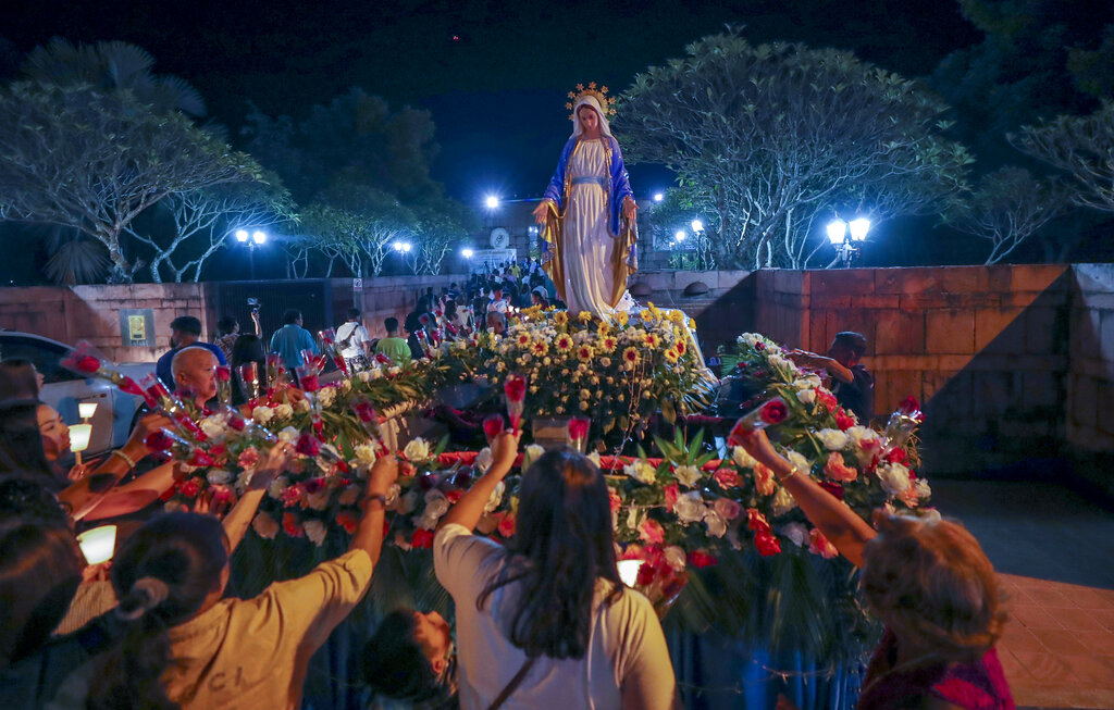 In this Friday, Oct. 18, 2019, photo, Catholic worshippers lay flowers at the base of a Mother Mary statue at the Christ Church in Songkhon village, Mukdahan province, northeastern of Thailand. There are about 388,000 Catholics in Thailand, representing 0.58 percent of the country's 69 million population. Photo: Sakchai Lalit / AP