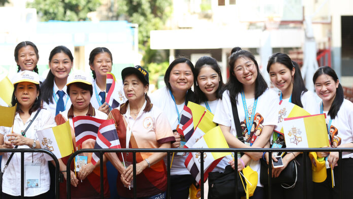 A group of young Catholics wait to welcome Pope Francis at the Assumption Cathedral on Nov. 22, 2019.