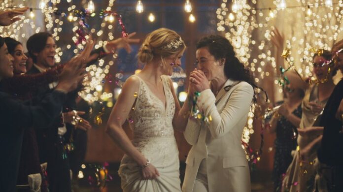 This image made from undated video provided by Zola shows a scene of its advertisement. The Hallmark Channel says it will reinstate same-sex marriage commercials that it had pulled from the network. Hallmark Cards CEO Mike Perry said in a statement Sunday, Dec. 15, 2019, that pulling the commercials “was the wrong decision.
