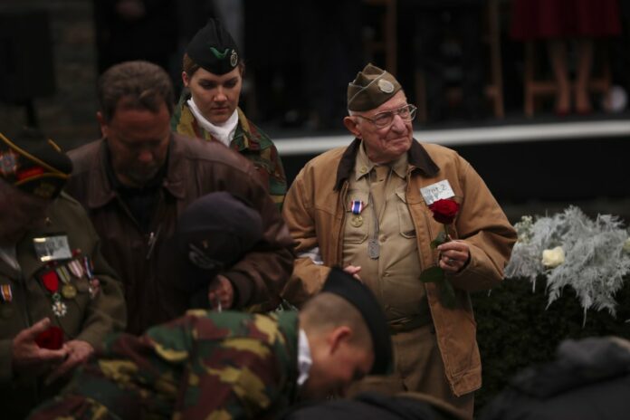 U.S. Battle of the Bulge veterans put flowers to pay tribute during a ceremony to commemorate the 75th anniversary of the Battle of the Bulge at the Mardasson Memorial in Bastogne, Belgium on Monday, Dec. 16, 2019. (AP Photo/Francisco Seco)