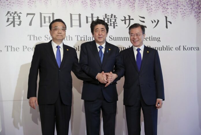 In this May 9, 2018, file photo, Chinese Premier Li Keqiang, left, Japanese Prime Minister Shinzo Abe, center, and South Korean President Moon Jae-in, right, pose for photographers prior to their summit in Tokyo. (AP Photo/Eugene Hoshiko, File)