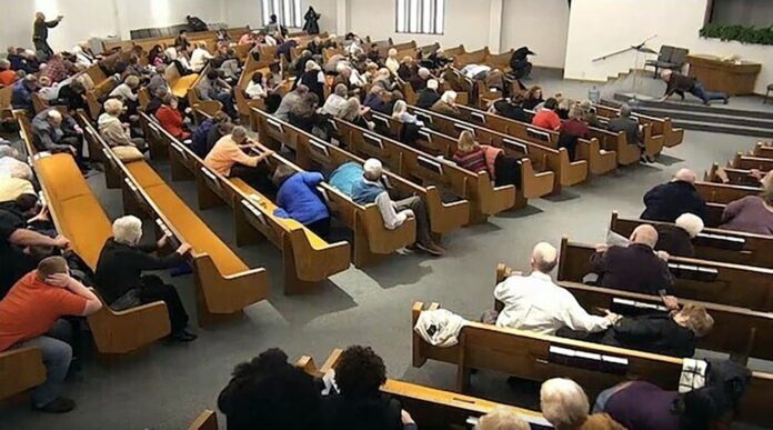 In this still frame from livestreamed video provided by law enforcement, churchgoers take cover while a congregant armed with a handgun, top left, engages a man who opened fire, near top center just right of windows, during a service at West Freeway Church of Christ, Sunday, Dec. 29, 2019, in White Settlement, Texas. (West Freeway Church of Christ/Courtesy of Law Enforcement via AP)