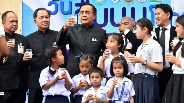 PM Prayuth Chan-ocha and schoolchildren pose for photos at a government event to promote drinking milk. Image: Government House PM Prayuth Chan-ocha and schoolchildren pose for photos at a government event to promote drinking milk. Image: Government House.