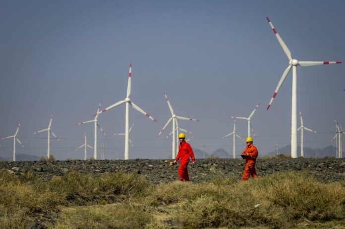 Workers check equipment at a wind power plant in Urumqi, northwest China's Xinjiang Uygur Autonomous Region, Sept. 18, 2018. Photo: Zhao Ge / Xinhua