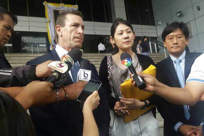 Gerald Margolis, center left, branch manager of Philip Morris in Thailand, talks to reporters at Criminal Court in Bangkok, Thailand, Friday, Nov. 29, 2019. The court has found the local unit of tobacco giant Philip Morris guilty of evading taxes by under-declaring the value of cigarettes it imported from the Philippines, and ordered the company to pay a fine of 1.2 billion baht ($39.7 million). Photo: AP