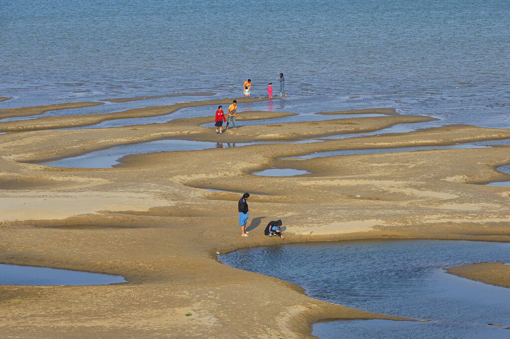 In this Wednesday, Dec. 4, 2019, photo, sightseers plays on a sandbar in the Mekong River in Nakhon Phanom province, northeastern Thailand. Photo: Chessadaporn Buasai / AP