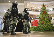 Hong Kong Clashes Resume in Shopping Centers, Streets Riot police past by a Christmas decor in a mall during a protest rally on Christmas Eve in Hong Kong on Tuesday, Dec. 24, 2019. More than six months of protests have beset the city with frequent confrontations between protesters and police. Photo: Kin Cheung / AP
