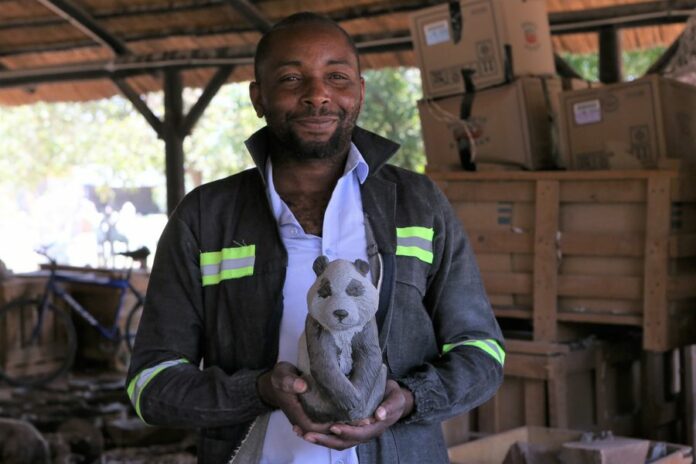 Zimbabwean sculpture artist Tendekai Tigere Tandi stands beside his works in his studio in Chitungwiza, Zimbabwe, December 7, 2019. (Xinhua/Chen Yaqin)