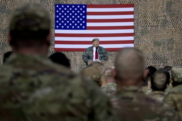 In this Dec. 26, 2018, file photo, President Donald Trump speaks to members of the military at a hangar rally at Ain al-Asad air base, Iraq. Iran struck back at the United States for the killing of a top Iranian general early Wednesday, Jan. 8, 2020, firing a series of ballistic missiles at Iraqi bases housing U.S. troops in a major escalation of tensions that brought the two longtime foes closer to war. (AP Photo/Andrew Harnik, File)