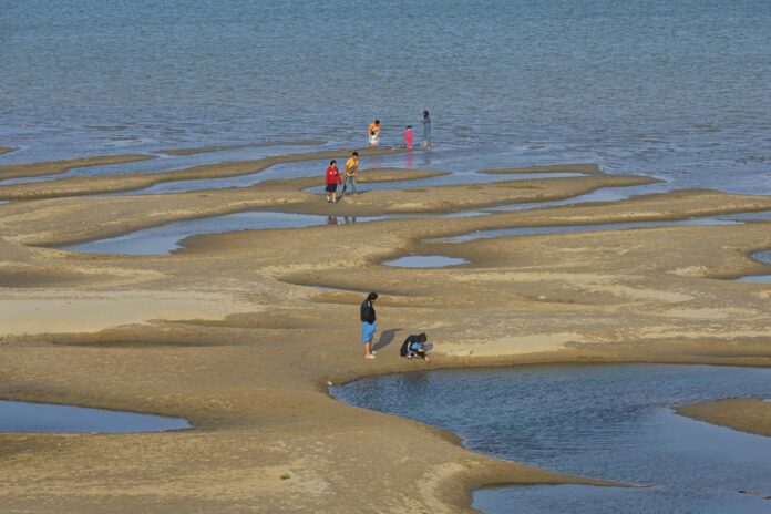 In this Wednesday, Dec. 4, 2019, photo, sightseers plays on a sandbar in the Mekong River in Nakhon Phanom province, northeastern Thailand. (AP Photo/Chessadaporn Buasai)