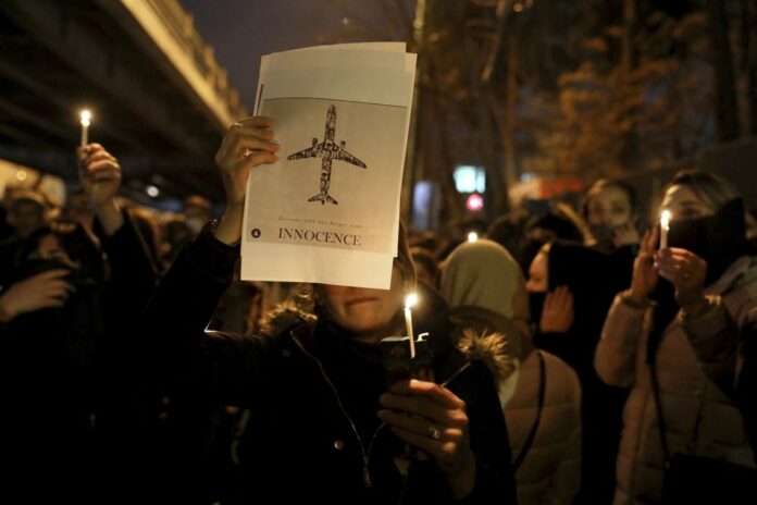 People gather for a candlelight vigil to remember the victims of the Ukraine plane crash, at the gate of Amri Kabir University that some of the victims of the crash were former students of, in Tehran, Iran, Saturday, Jan. 11, 2020. (AP Photo/Ebrahim Noroozi)
