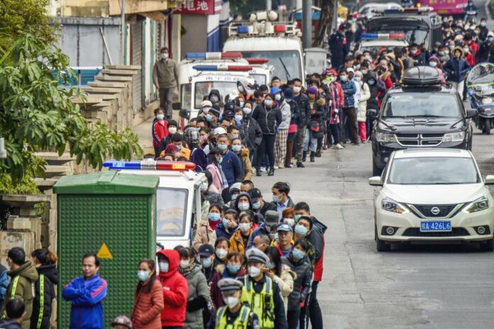 People line up to buy face masks from a medical supply company in Nanning in southern China's Guangxi Zhuang Autonomous Region, Wednesday, Jan. 29, 2020. (Chinatopix via AP)