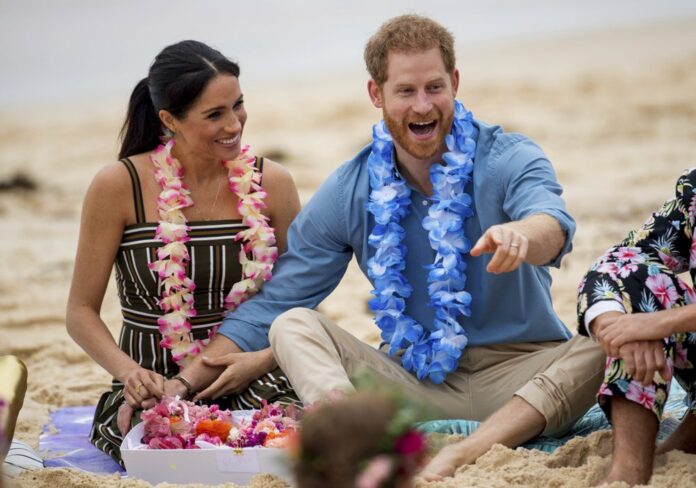 In this Friday, Oct. 19, 2018 file photo Britain's Prince Harry and Meghan, Duchess of Sussex meet with a local surfing community group, known as OneWave, raising awareness for mental health and wellbeing in a fun and engaging way at Bondi Beach in Sydney, Australia. (Dominic Lipinski/Pool via AP)
