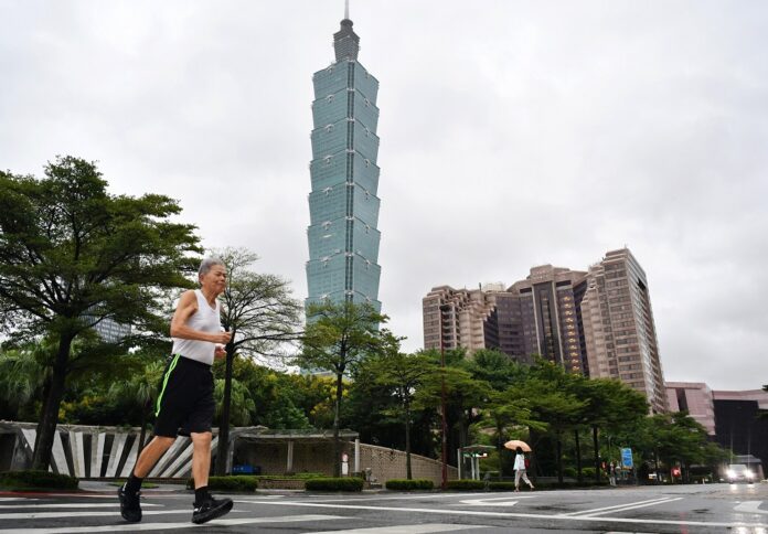 A citizen runs in front of the Taipei 101 skyscraper in Taipei, southeast China's Taiwan, on Oct. 1, 2019. (Xinhua/Chen Bin)
