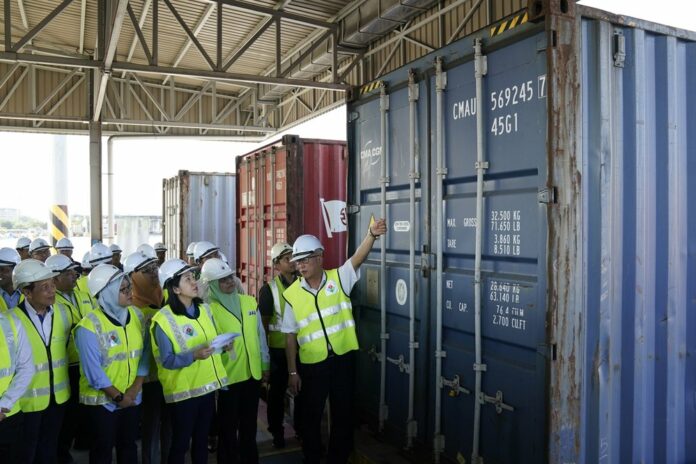 Malaysia's Environment Minister Yeo Bee Yin, third from left, inspects a container with plastic waste at a port in Butterworth, Malaysia, Monday, Jan. 20, 2020. (AP Photo/Vincent Thian)