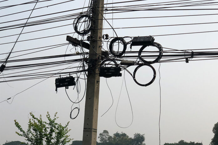 Loose telephone wires at the scene where two tourists were swept off their motorcycle in Kanchanaburi City on Jan. 19, 2020. Loose telephone wires at the scene where two tourists were swept off their motorcycle in Kanchanaburi City on Jan. 19, 2020.