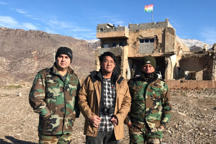 Pongsorn Bhumiwat, center, stands next to Kurdish militias during his trip to Iraqi Kurdistan. Photo: Pongsorn Bhumiwat / Courtesy