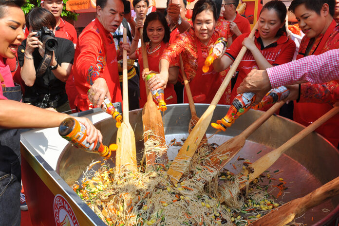 Festivalgoers use their paddles to stir fry noodles during Chinese New Year celebration on Yaowarat Road on Feb. 5, 2019.