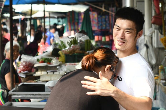 Future Forward leader Thanathorn Juangroongruangkit embraces his supporter during his visit to Wongwian Yai Market on Jan. 19, 2020.