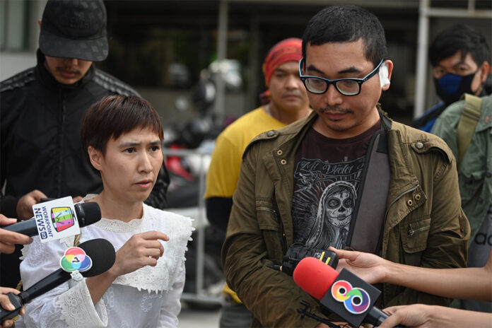 GrabBike driver Apichart Maneerat, right, and his wife speaking to reporters after he filed a complaint to the police at Phaholyothin Police Station on Jan. 24, 2020.