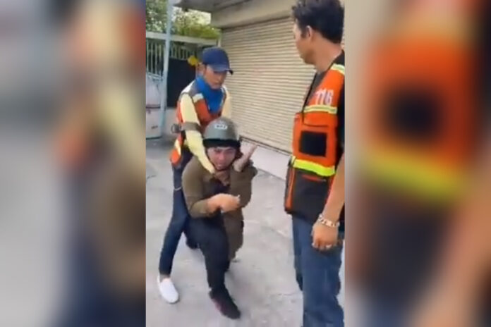 A still from the video clip showing GrabBike driver Apichart Maneerat being assaulted by motorcycle taxi drivers on Jan. 24, 2020. A still from the video clip showing GrabBike driver Apichart Maneerat being assaulted by motorcycle taxi drivers on Jan. 24, 2020.
