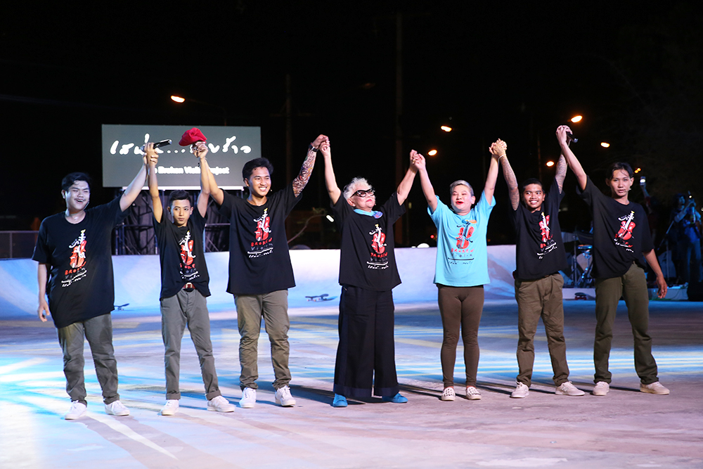 Director Patravadi Mejudhon, center, holds hands with juvenile cast members.