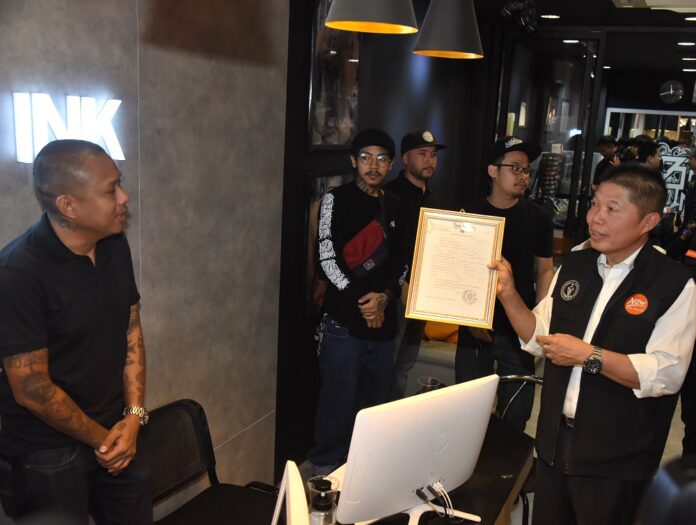 An official inspects health certificate at a tattoo parlor in Bangkok on Sep. 5, 2018.