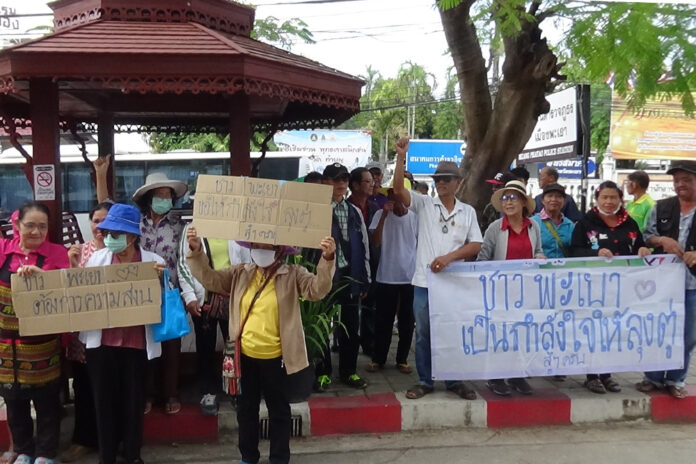Supporters of PM Prayuth Chan-ocha hold banners in front of Phayao city police station demanding police to cancel the “Run Against Dictatorship” event on Jan. 5, 2020.