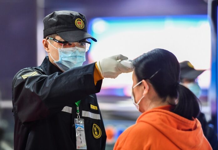 Passengers line up to have body temperatures measured at a station in Zhengzhou, central China's Henan Province, Jan. 26, 2020. (Xinhua/Li Jianan)